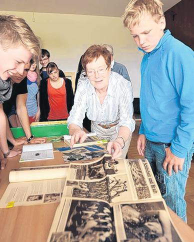 Gisela Engelhardt zeigt den Sportschülern alte Olympiaberichte in DDR-Illustrierten.