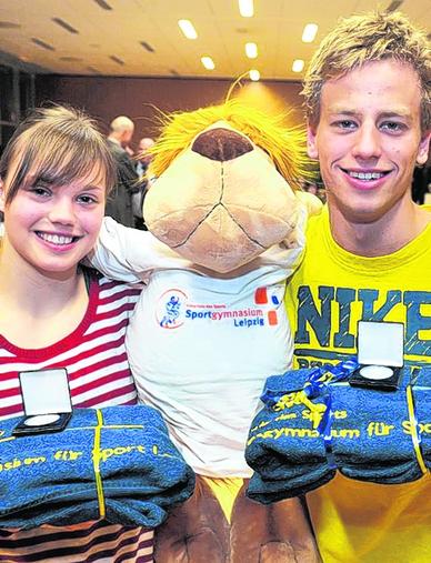 Karolin Wagner und Tobias Horn posieren mit Sportgymnasium-Maskottchen Sporti. Karolin Wagner und Tobias Horn posieren mit Sportgymnasium-Maskottchen Sporti.